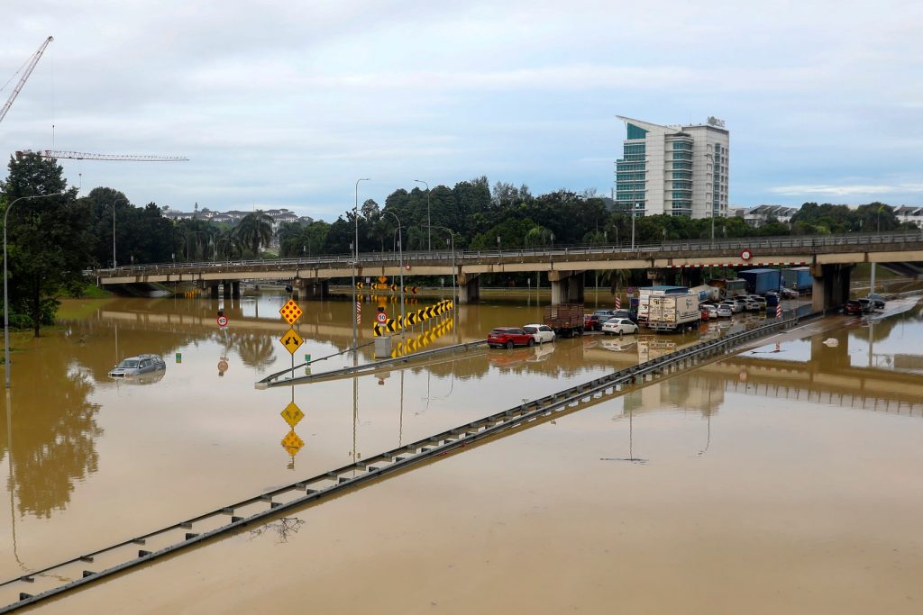 Vehicles stuck in the middle of a flooded highway in Shah Alam, Selangor. -EPA-EFE/FAZRY ISMAIL